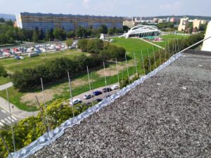 Hroty proti holubům na kraji střechy panelového domu v Praze